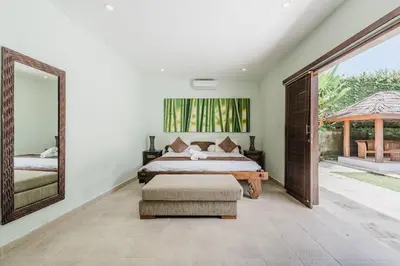 a bedroom with a bed and a large mirror at 9 Bedroom Villa Vista Seminyak in Seminyak