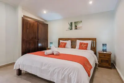 a bedroom with a large bed with orange pillows at 10 Bedroom Villa Vista Seminyak in Seminyak