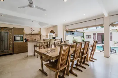 a kitchen and dining room with a wooden table and chairs at 10 Bedroom Villa Vista Seminyak in Seminyak