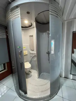 a bathroom with a shower and a toilet at trees inn Bali Denpasar in Denpasar