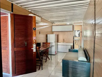 a small kitchen with a table and a refrigerator at trees inn Bali Denpasar in Denpasar