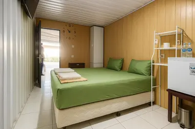 a bedroom with a green bed in a room at trees inn Bali Denpasar in Denpasar