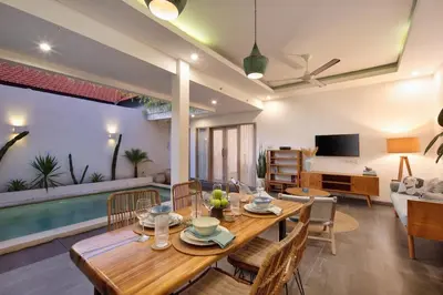 a dining room and living room with a table and chairs at Stylish 2BR Villa in Seminyak with Private Pool in Seminyak