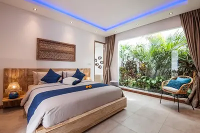 a bedroom with a large bed and a large window at Spacious 4 BR villa Seminyak garden and pool in Seminyak