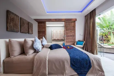 a bedroom with a large bed and a couch at Spacious 4 BR villa Seminyak garden and pool in Seminyak