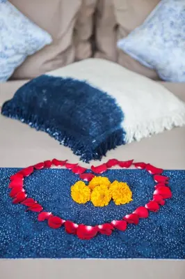 a blue blanket with yellow flowers on a bed at Spacious 4 BR villa Seminyak garden and pool in Seminyak