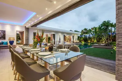 a dining room with a glass table and chairs at Spacious 4 BR villa Seminyak garden and pool in Seminyak