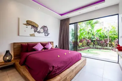 a bedroom with a purple bed with a large window at Seminyak Modern villa 4 BR fully serviced 5 in Seminyak