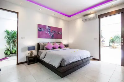 a bedroom with a large bed with pink pillows at Seminyak Modern villa 4 BR fully serviced 5 in Seminyak