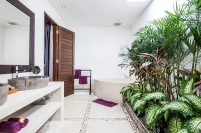 a bathroom with a tub and plants at Seminyak Modern villa 4 BR fully serviced 5 in Seminyak