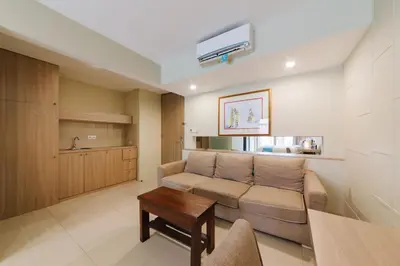 a living room with a couch and a table at Sans Vibes Astana Residence Seminyak in Seminyak