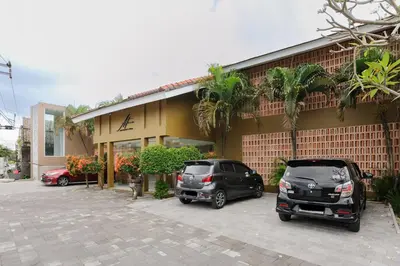 two cars parked in a parking lot in front of a building at Tan's Astana Villa's by The Lavana in Seminyak