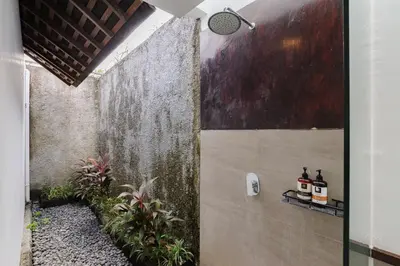 a bathroom with a painting on the wall at Tan's Astana Villa's by The Lavana in Seminyak