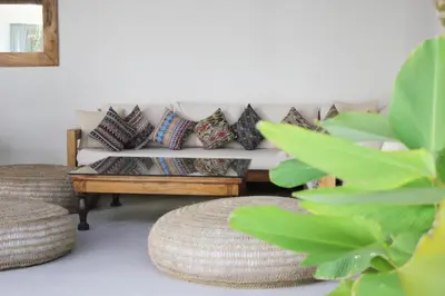 a living room with a white couch with pillows at NEW 4 BDR Villa Rooftop & pool Seminyak Petitenget in Seminyak