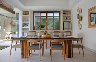 a dining room with a wooden table and chairs at NEW 4 BDR Villa Rooftop & pool Seminyak Petitenget in Seminyak