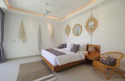 a bedroom with a bed and a chair and mirrors at NEW 4 BDR Villa Rooftop & pool Seminyak Petitenget in Seminyak