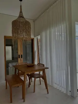 a dining room with a table and chairs and a chandelier at Shine sunset villa in Kerobokan
