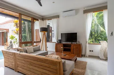 a living room with a couch and a tv at Villa Tropea by BaliSuperHost in Seminyak