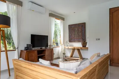 a living room with a couch and a tv at Villa Tropea by BaliSuperHost in Seminyak