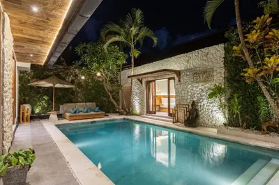 a swimming pool in a backyard with a house at Villa Tropea by BaliSuperHost in Seminyak