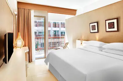 a bedroom with a white bed and a large window at Four Points by Sheraton Bali, Kuta in Kuta