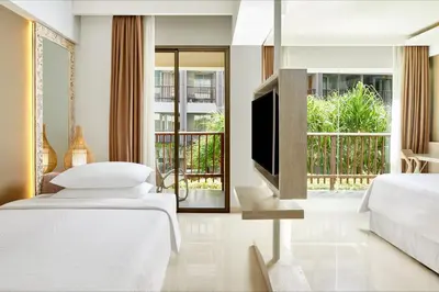 a bedroom with two beds and a flat screen tv at Four Points by Sheraton Bali, Kuta in Kuta