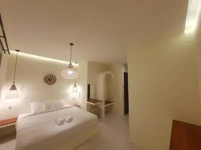 a bedroom with a white bed and two lights at Villa Kiara Sanur in Sanur