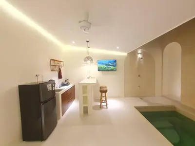 a kitchen with a refrigerator and a table in a room at Villa Kiara Sanur in Sanur
