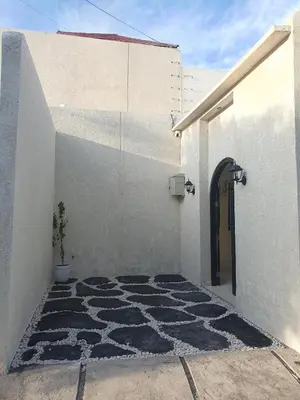 a white building with a door and a potted plant at Villa Kiara Sanur in Sanur