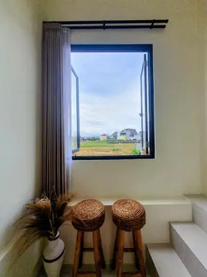 two stools in front of a window with a plant at Villa Kiara Sanur in Sanur