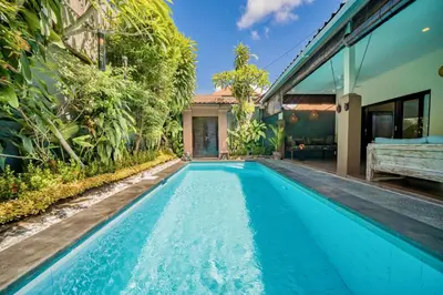 an infinity pool in the backyard of a villa at Villa Kiwi Seminyak in Seminyak