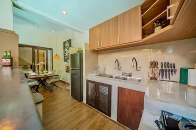 a kitchen with a stainless steel refrigerator and a table at Villa Kiwi Seminyak in Seminyak