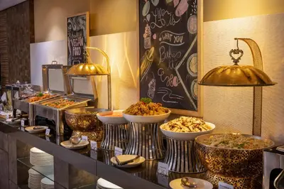 a buffet with several bowls of food on a counter at Anathera Resort Kuta Bali Airport in Kuta