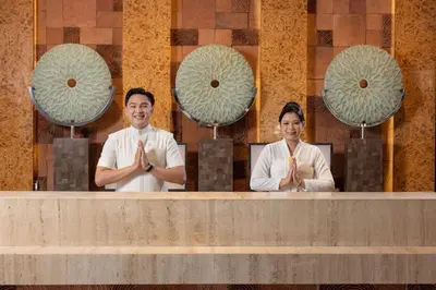 a man and a woman standing behind a counter with their hands at Anathera Resort Kuta Bali Airport in Kuta