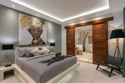 a bedroom with a large bed with a large painting on the wall at Amazing 4 BR villa with garden, pool in Seminyak in Seminyak