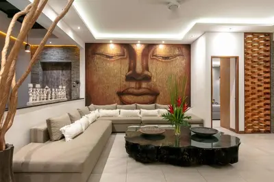 a living room with a couch and a painting of a face at Amazing 4 BR villa with garden, pool in Seminyak in Seminyak