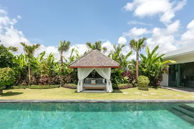 a gazebo next to a swimming pool at Amazing 4 BR villa with garden, pool in Seminyak in Seminyak