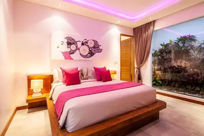 a bedroom with a large bed with red pillows at Seminyak 5 bd villa avec Chill-out extérieur in Seminyak