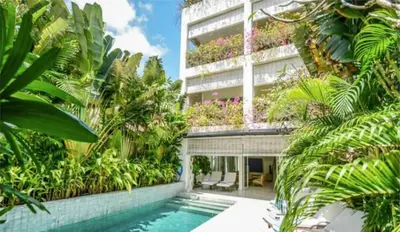 a building with a swimming pool in front of a building at 4BR Group Holiday, Walk to Fitness, Food, Beach in Seminyak