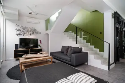 a living room with a couch and a staircase at 4BR Group Holiday, Walk to Fitness, Food, Beach in Seminyak