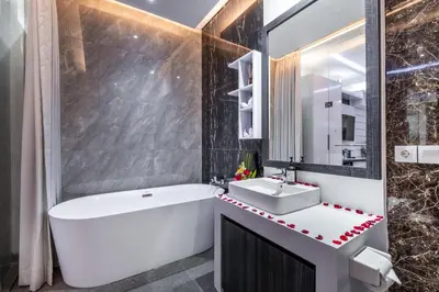a bathroom with a white tub and a sink at Villa Rama by JB Villas in Seminyak