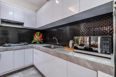 a white kitchen with a sink and a microwave at Villa Rama by JB Villas in Seminyak