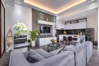 a living room with a couch and a kitchen at Villa Rama by JB Villas in Seminyak