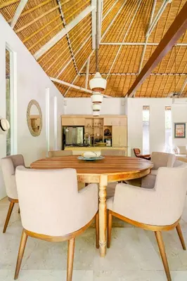 a dining room with a wooden table and chairs at Villa Bliss Umalas in Kerobokan