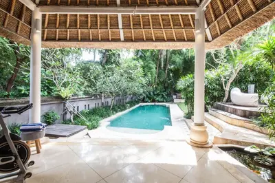 a swimming pool in a backyard with a pergola at Villa Bliss Umalas in Kerobokan