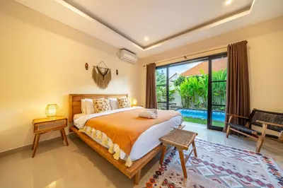 a bedroom with a bed and a large window at New Villa in the best area in Kuta