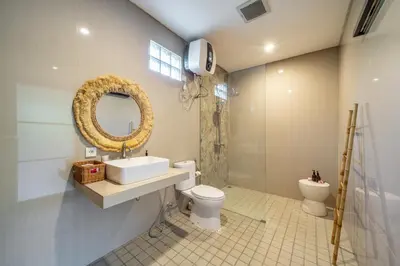 a bathroom with a sink and a toilet and a mirror at New Villa in the best area in Kuta