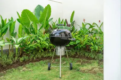 a grill sitting on a stand in the grass at New Villa in the best area in Kuta