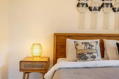 a bedroom with a bed and a table with a lamp at New Villa in the best area in Kuta