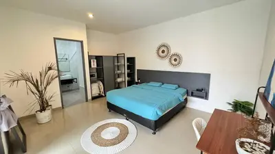 a bedroom with a bed and a table and a mirror at Ulun Kubu Villa in Kerobokan